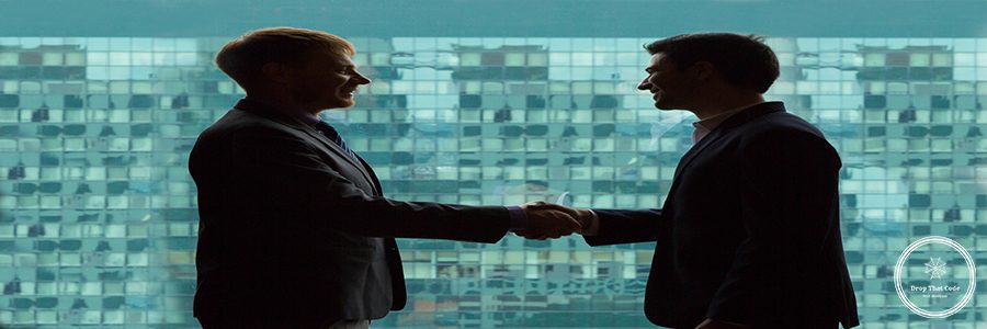 Silhouettes of businessmen shaking hands against big window in modern office building