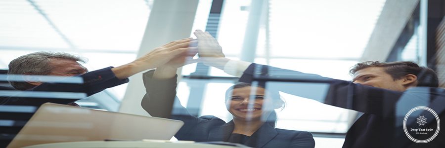 Businesspeople giving a high five to each other in office