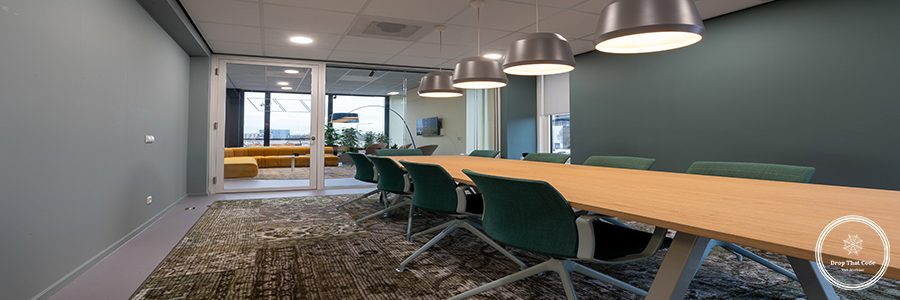 Several chairs put next to a table in a room with a patterned carpet