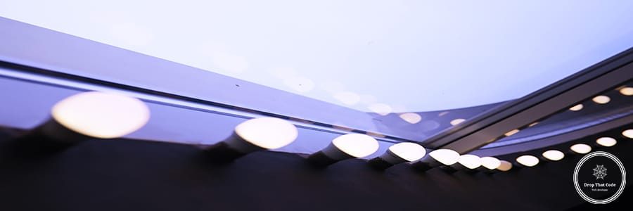 Circus lights in a row on red ceiling. Lamp hanging from the ceiling in the building. Arranged in a long line