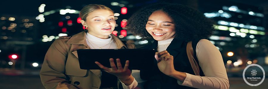 City, women and discussion with tablet at night for creative planning, website and outdoor travel to work. Happy, friends and smile with tech in street for journey, communication or email of feedback.