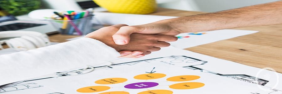 close-up-two-businessmen-shaking-hands-desk