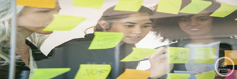 Confident businesswomen writing notes on stickers for startup. Successful experienced managers in suits meeting in conference room and planning strategy. Teamwork, business and management concept