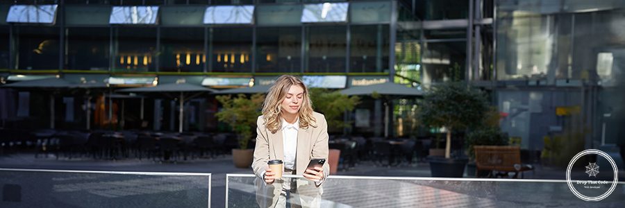 Corporate woman drinking her coffee and looking at mobile phone. Businesswoman relaxing on her lunch break.
