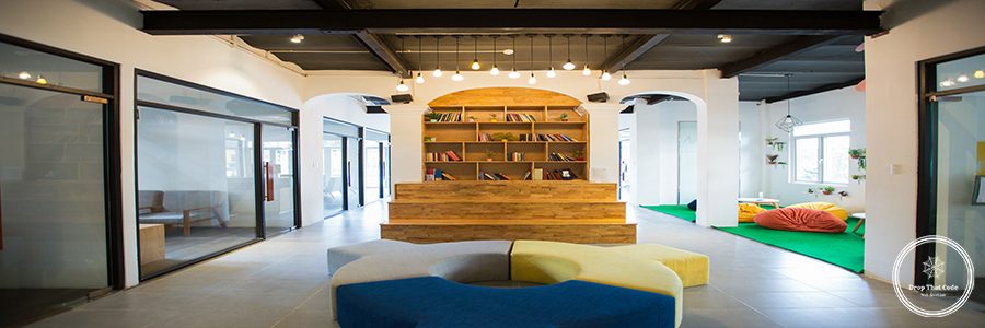Cozy lobby with bookshelf and modern furniture. Wooden stairs in front of bookshelf. Receiving office concept