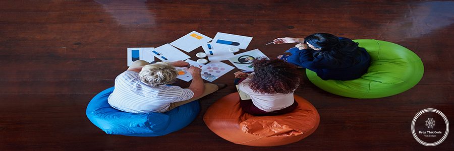 Creative designers, above meeting and business planning, design teamwork or brainstorming for office website ideas. Group of people, collaboration and logo documents for branding with paperwork.