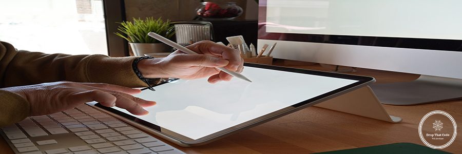 Cropped shot of designer using graphics tablet while working with computer at studio or office