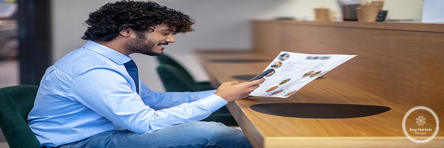 Online order. Curly-haired businessman choosing lunch menu and ordering online