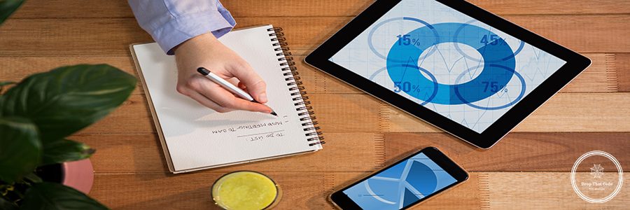 Digital composition of digital tablet and mobile phone on table with hand writing on notebook