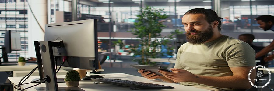 Employee looking at PC monitor, drinking coffee, checking data needed for finding business insights and finishing project task. Man analyzing data on computer, enjoying beverage, camera B