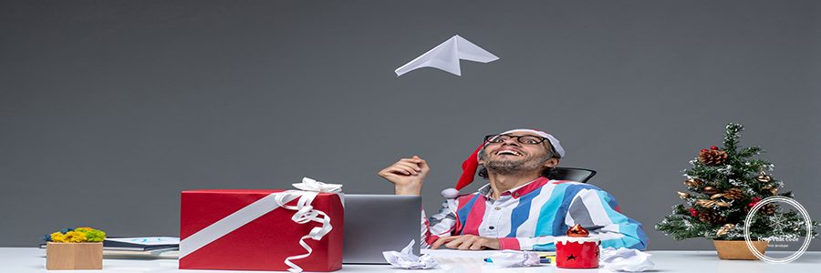 front view male worker sitting in his working place playing with paper plane on grey background business job xmas office holiday