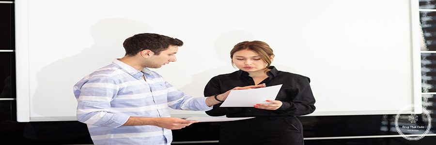 a front view young attractive businesswoman in black shirt along with young man discussing graphics on the desk while young lady presents her work reading document job building presentation