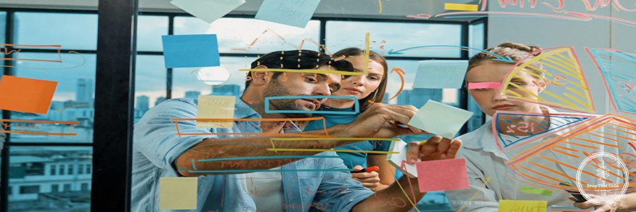 Group of happy professional business team working together, discussing and writing at sticky notes about marketing idea, plan, strategy at glass wall with graph and colorful sticky notes. Tracery