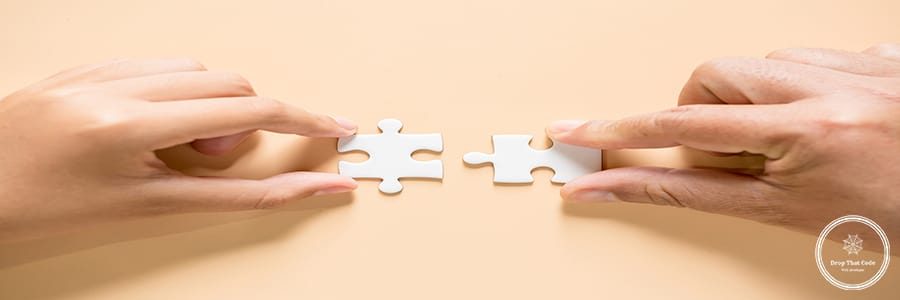 hand connecting two puzzle pieces on table background, business strategy concept