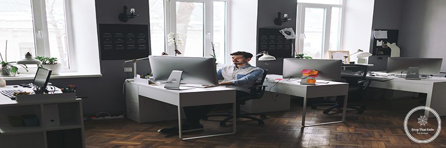 Young man working on computer while sitting at his working place in office