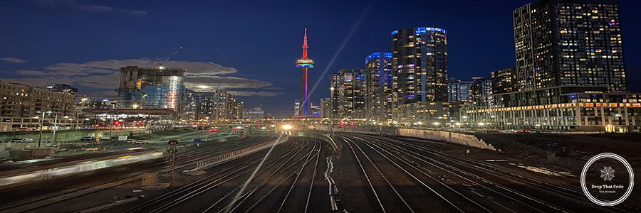 illuminated-railroad-tracks-amidst-buildings-city-night