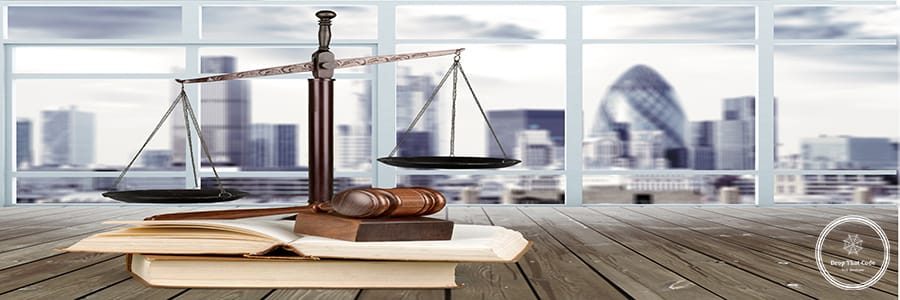 Justice Scales and books and gavel on cityscape background