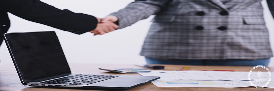 laptop-near-people-shaking-hands