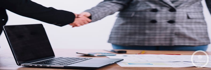 laptop-near-people-shaking-hands