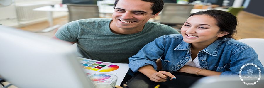 Male and female graphic designers working on computer in office