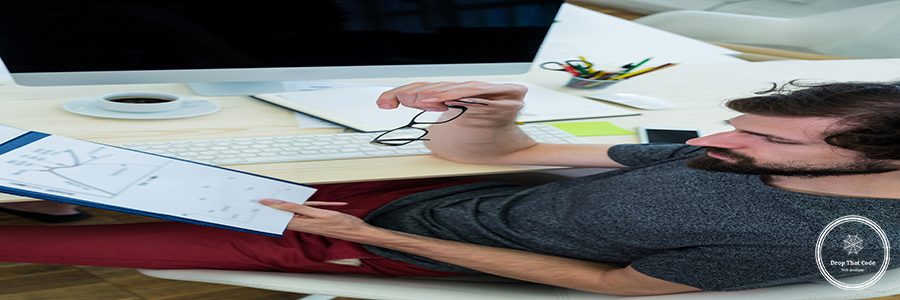 Male graphic designer looking at a document in office
