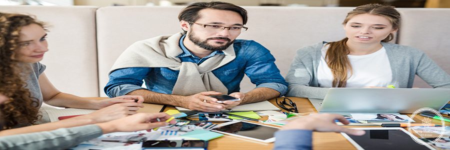 Businessman with smartphone listening to co-worker at meeting