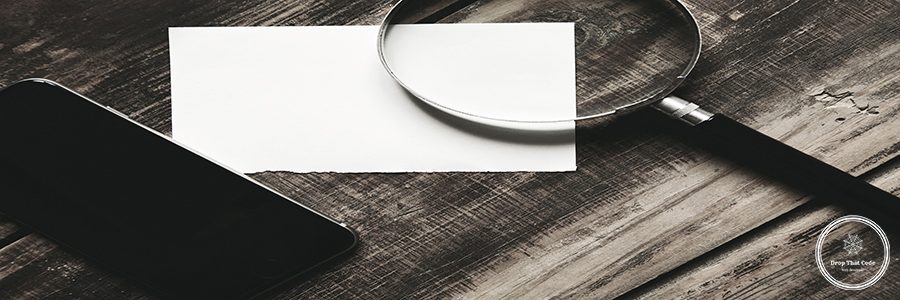 Mobile smartphone, magnifier and sheet of white paper isolated on black farm wooden table Mysterious detective game concept. Closeup side view