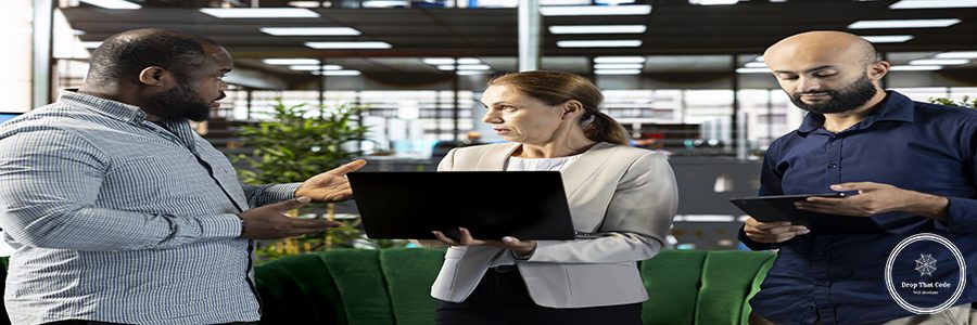 Multiracial workers using laptop device to write emails, solving tasks. Staff members typing on notebook keyboard in office, making sure documents are quality assurance compliant