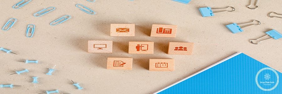 Office supplies concept with icons on wooden cubes, stationery set on paper background flat lay.