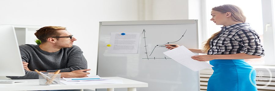 Young economist making presentation of financial changes on market on whiteboard