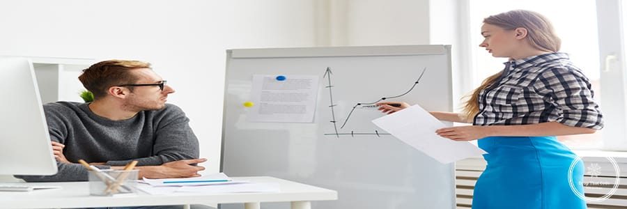 Young economist making presentation of financial changes on market on whiteboard
