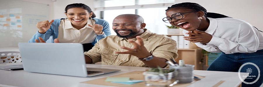 Shot of a group of businesspeople using a laptop and cheering in a modern office