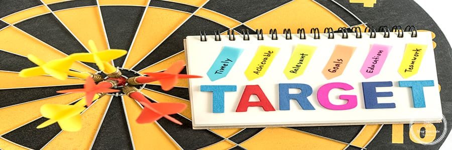 six dart in bullseye with words target on the notebook with handwriting timely achievable relevant goals education teamwork over dartboard background, Business success concept