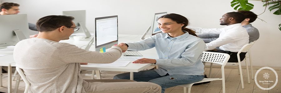 Smiling colleagues partners shaking hands in office, happy young woman manager handshaking satisfied client customer making deal agreement, thanking for help, good teamwork or hiring intern concept