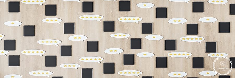 Social network rating concept with black cell phones on wooden surface and speech bubbles with stars. 3D rendering
