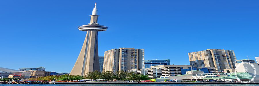 Toronto skyline in the day over lake with urban architecture and blue sky