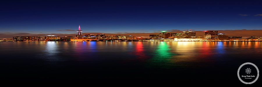 Toronto cityscape panorama at dusk over lake with colorful light.