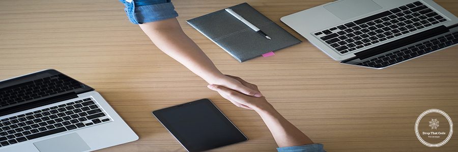 Two Businesspeople shaking hands indoors.