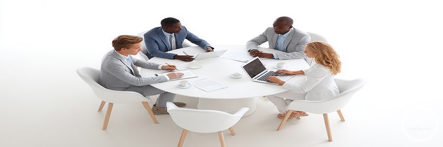 Business team collaborating, using digital devices during strategic planning session in contemporary workspace
