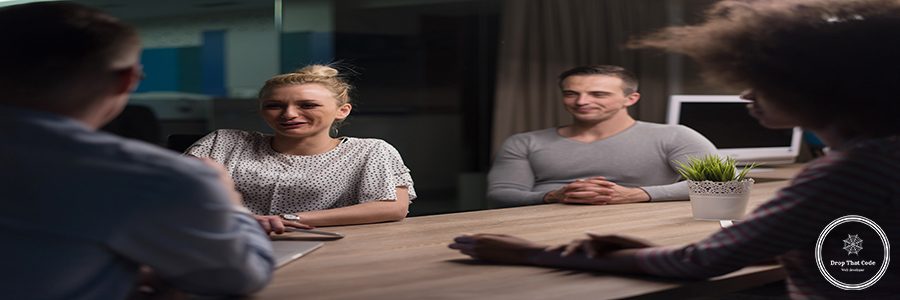 Multiethnic startup business team on meeting in modern night office interior brainstorming, working on laptop