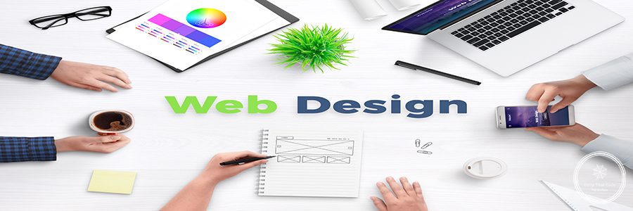 Web design text on work desk surrounded with web development team, devices, projects, and ideas on paper. Concept of team meeting.