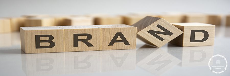 word Brand on wooden cubes, gray background. Reflection on the mirrored surface of the table. Selective focus.