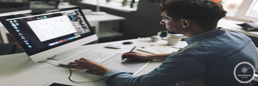 Modern designer sitting in front of computer and working in office