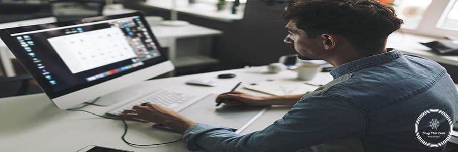 Modern designer sitting in front of computer and working in office